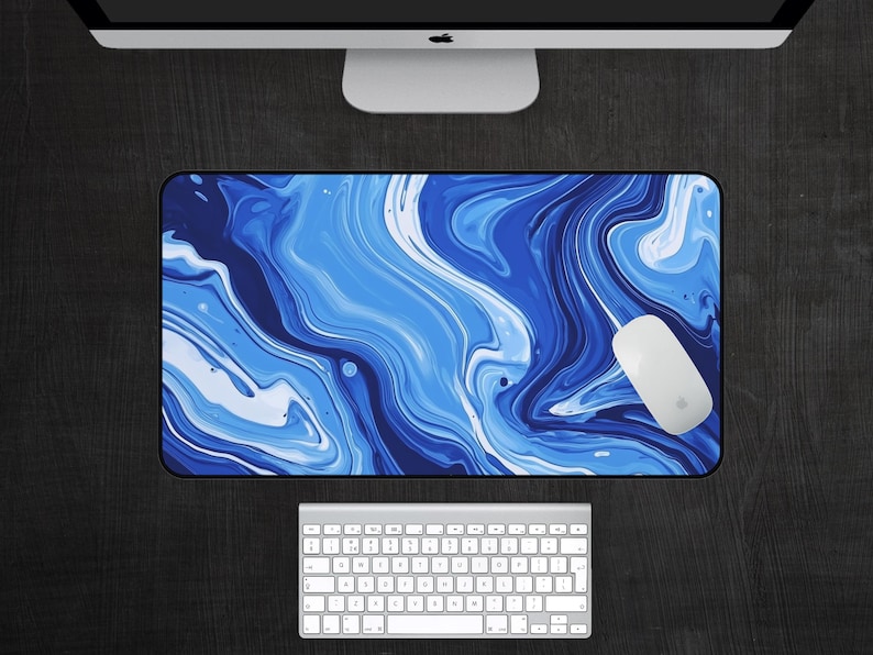 May include: Blue and white abstract marble design desk mat. The mat has a swirling pattern of blue and white paint.