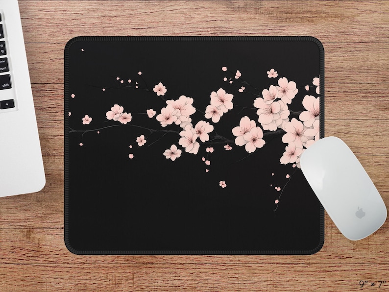 Puede incluir: Alfombrilla de rat&oacute;n negra con un dise&ntilde;o de flores de cerezo rosas sobre un fondo negro.