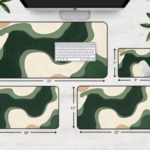 May include: A set of four desk mats featuring an abstract design in green, beige, and brown. The largest mat is 78.7 cm long and 39.4 cm wide, with a keyboard on top. A mouse pad and two smaller mats are also included.