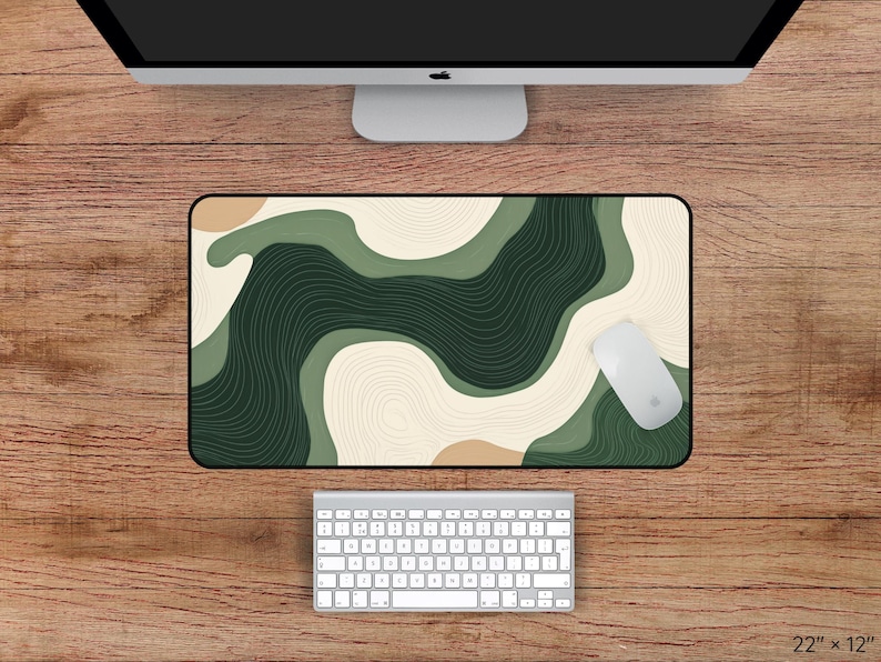 May include: A rectangular desk mat with a black border, featuring an abstract design in shades of green, beige, and brown. A white computer mouse rests on the mat. The mat measures 56 cm by 30 cm.