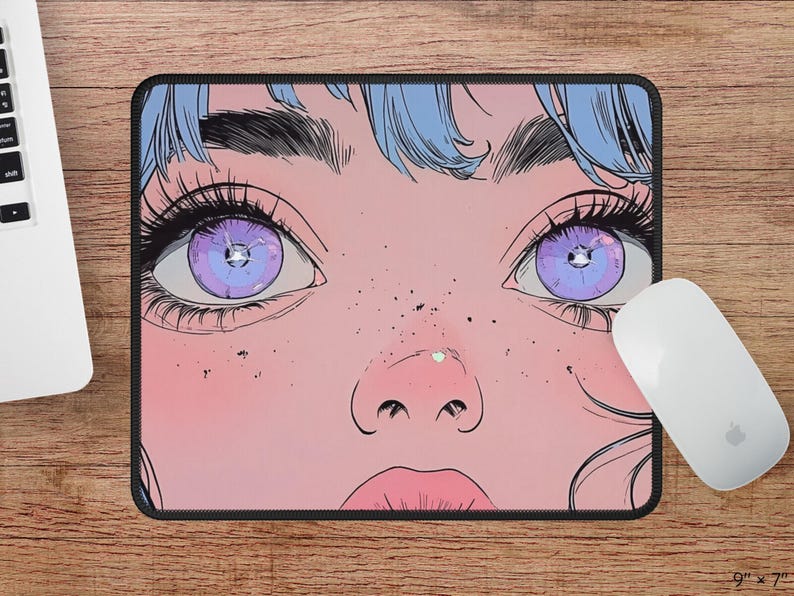 Op de afbeelding: Een muismat met een close-up van een vrouwengezicht met grote, paarse ogen en roze huid. De vrouw heeft blauw haar en is getekend in een cartoon stijl.