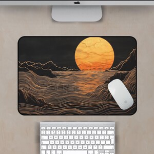 May include: A black and gold mouse pad with a minimalist design of a large orange sun setting over a wavy ocean. The waves are drawn with thin lines.