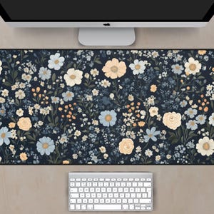 May include: A blue and white floral patterned desk mat with a black border. The mat is designed to protect your desk surface from scratches and spills.