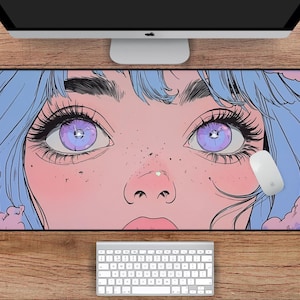 Op de afbeelding: Een anime-stijl illustratie van een vrouwen gezicht met grote paarse ogen, in blauwe en roze tinten. De afbeelding is op een muismat met een witte computermuis in de rechterbenedenhoek.