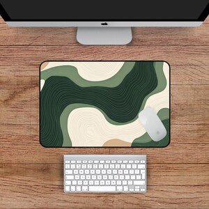 May include: A rectangular mouse mat with a green and beige abstract design, a white mouse, and a white keyboard. The mouse mat measures 45.7 x 30.5 cm.