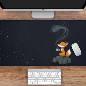May include: A black mouse pad with a starry night design. A cartoon fox with an orange and white tail is sitting on a rock, holding a cup of coffee. The fox is surrounded by a wisp of smoke.