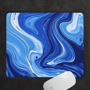 May include: Blue and white abstract marble design mouse pad. The design features swirling, flowing lines of blue and white paint.