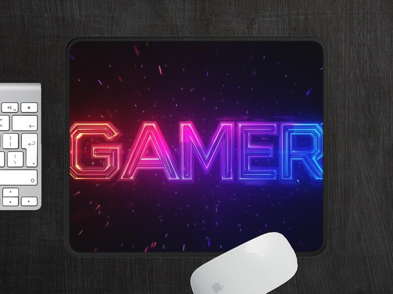 May include: A black mouse pad with a neon pink and blue "GAMER" graphic. The graphic is surrounded by a dark blue background with white speckles.