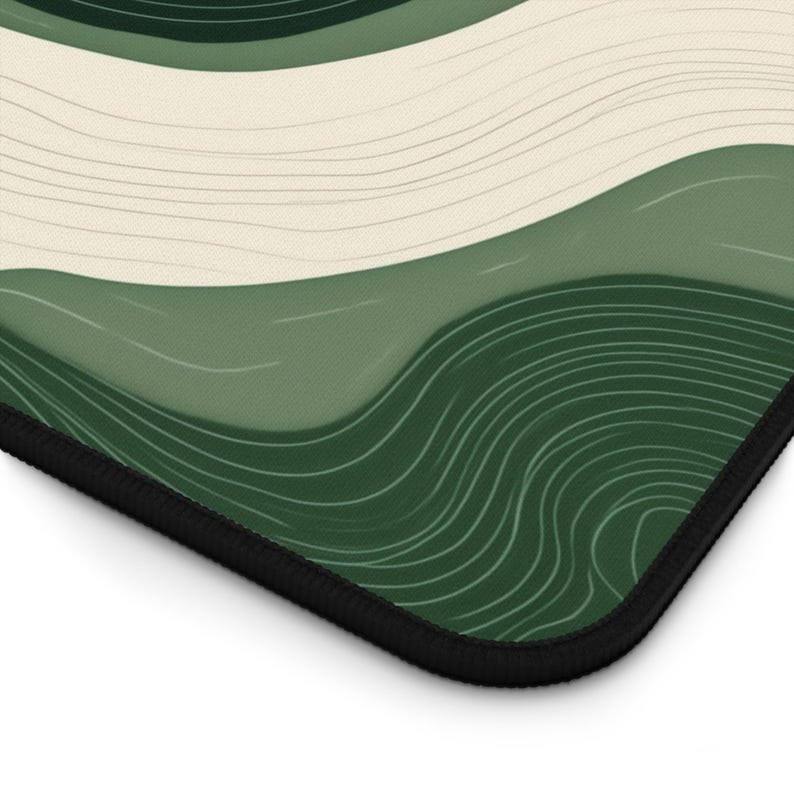 May include: A rectangular mousepad with a black border, featuring an abstract design. The pattern consists of flowing waves in shades of green and cream, with fine white lines. The colour scheme is muted and natural.