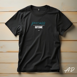May include: Black t-shirt with the text "process outcome" in blue and white lettering.