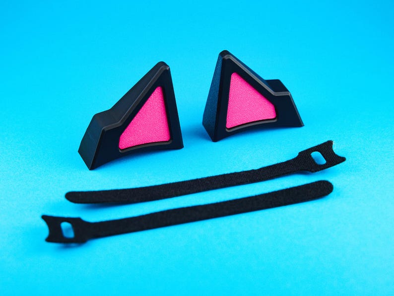 May include: Black cat ear headband accessories with pink inner ear detail. Includes two black cat ear pieces and two black straps for attachment. The ears are made of a hard plastic material.