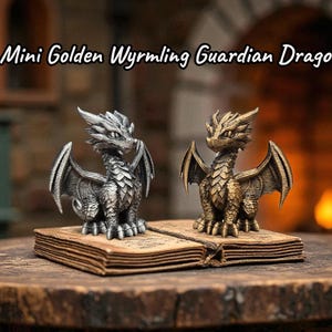 May include: Two miniature dragon figurines, one silver and one gold, sit on an open book. The dragons have detailed wings and scales. The text "Mini Golden Wyrmling Guardian Dragon" is above the figurines. The background includes a fireplace.