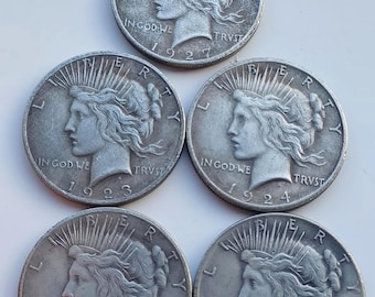 Restikes de monedas de dólar de la paz de los Estados Unidos, bañadas en plata.
