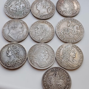 Peut inclure: Collection de neuf pièces de monnaie anciennes en argent, chacune avec des gravures détaillées de figures historiques et de scènes équestres. Les pièces sont disposées sur une surface claire, mettant en valeur leurs motifs complexes et leur aspect vieilli.