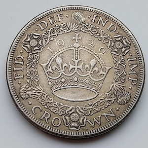 Peut inclure: Une pièce de monnaie britannique de 1929, de couleur argentée, présentant une couronne royale centrale entourée d'une couronne de chardons et de roses. Le texte indique FID DEF IND IMP et CROWN, avec la date 1929 divisée par la couronne.