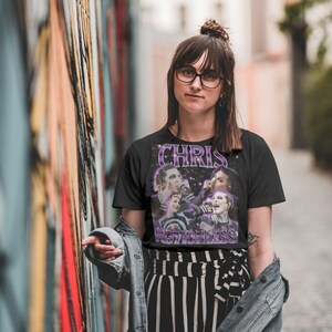 May include: Black t-shirt with a graphic print of a band called "Chris Motionless". The band members are pictured in a black and white photo with a purple and white star background.