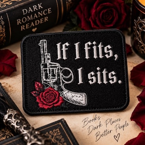May include: A rectangular black embroidered patch featuring a white line-art illustration of a revolver and a red rose. The text "If I fits, I sits." is embroidered in white. The patch has a black border and a textured fabric surface.