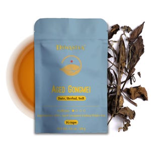 May include: A light blue pouch of Aged Gongmei tea with gold lettering and a leaf logo. The text reads "Date, Herbal, Soft" and "14 cups". The net weight is 1.0 oz / 28 g. Dried tea leaves are scattered to the right.