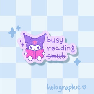 Könnte beinhalten: Holografischer Aufkleber mit einer lila Cartoonfigur, die ein rosa Buch liest. Der Text "busy reading smut" ist lila geschrieben. Der Hintergrund ist ein hellblaues Karomuster.