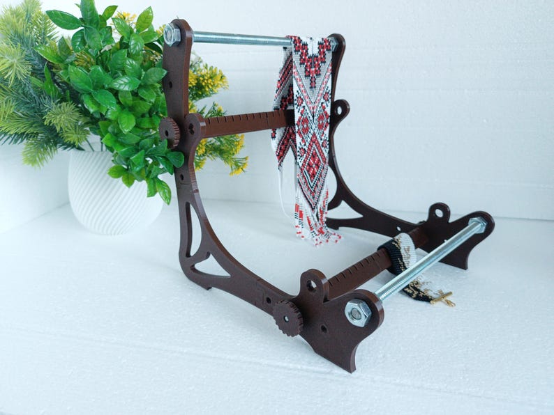 May include: A brown wooden stand with a metal rod and a beaded necklace hanging from it. The stand has a ruler on the side and is designed to hold jewelry.