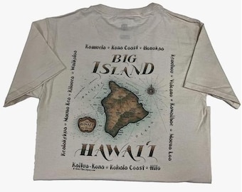Puede incluir: Camiseta beige claro con un mapa de la Isla Grande de Hawái. La camiseta muestra las palabras "Big Island Hawaii" y nombres de lugares. El mapa es marrón y beige.