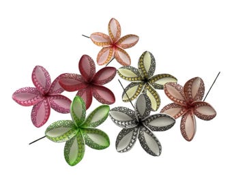 Puede incluir: Un conjunto de siete flores de cinco pétalos con forma de plumeria en varios colores, incluyendo rosa, rojo, verde, amarillo, gris y melocotón. Cada pétalo presenta un patrón geométrico triangular repetitivo y cada flor tiene un tallo de alambre fino.