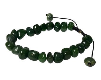 May include: A dark green beaded bracelet with a sliding knot closure. The bracelet is made of polished, irregularly shaped stones. The stones are a deep, rich green color. The bracelet is on a white background.