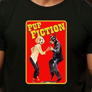 May include: Black t-shirt featuring a graphic of two dogs dancing, with the text "PUP FICTION" in yellow letters on a red background. The dogs are dressed in human clothing, with one wearing a suit and the other a button-down shirt.