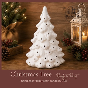 May include: A white ceramic Christmas tree figurine with a textured, matte finish and numerous small circular openings throughout its branches. The tree has a conical shape with layered, stylized boughs and is designed for decorative painting.