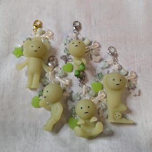 Peut inclure: Une tasse en céramique blanche avec une anse noire et le texte "But First, Coffee" en gras noir. La tasse est posée sur un fond flou, suggérant un cadre chaleureux.