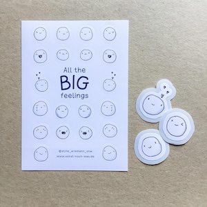 Könnte beinhalten: Ein weißer Aufkleberbogen mit zwanzig runden Stickern, die verschiedene handgezeichnete Gesichtsausdrücke und den Text All the BIG feelings zeigen. Rechts daneben liegen drei einzelne runde Sticker mit Gesichtern. Der Text enthält Social-Media- und Website-Informationen.