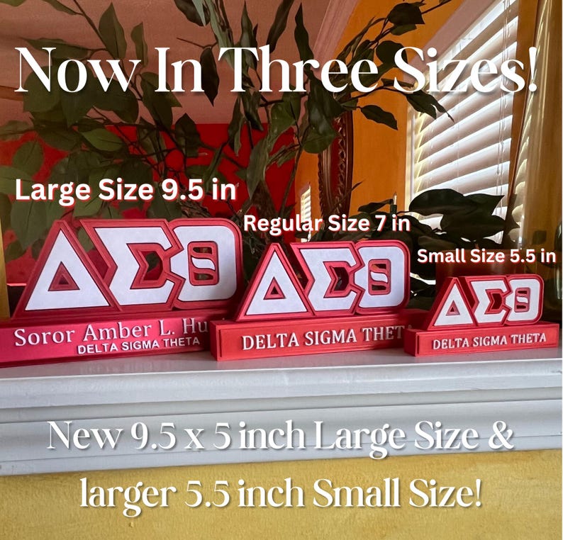 Może przedstawiać: Trzy rozmiary czerwono-białych tabliczek sororities Delta Sigma Theta z literami "&Delta;&Sigma;&Theta;" w kolorze białym. Tabliczki znajdują się na p&oacute;łce z tekstem "Now In Three Sizes!" nad nimi. Największa tabliczka ma 9,5 cala, środkowa 7 cali, a najmniejsza 5,5 cala.