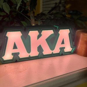 Caixa de luz com letras gregas inspirada em Alpha Kappa Alpha com LED.