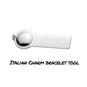 May include: A silver tool for opening and closing Italian charm bracelets. The tool has a round, smooth end and a flat, rectangular end.  ITALIAN CHARM BRACELET TOOL is printed on the bottom of the image.
