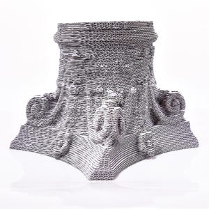 May include: A gray and white sculpture with a layered, textured appearance. The artwork features a detailed, architectural design with curved and circular elements. The piece is made of corrugated cardboard and sits on a white surface.