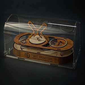 May include: A wooden clock with a clear acrylic cover. The clock face has a white background with black markings and a red hand. The clock is labelled "TIME HUNTER" with the text "tempus fugitum hostium est".