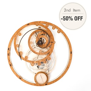 Può includere: Orologio da parete in legno con un design a spirale unico. L'orologio presenta una cornice in legno marrone chiaro con ingranaggi intricati e un piccolo quadrante circolare. Il testo "2nd Item -50% OFF" è in un cerchio bianco.
