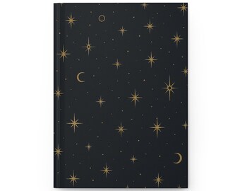 May include: A closed journal with a black cover featuring a celestial design. The cover is adorned with a pattern of gold stars, moons, and small dots against a dark background. The journal has a clean, minimalist aesthetic.