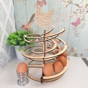 May include: Wooden egg holder shaped like a spiral with a chicken on top. The holder is made of natural wood and has a rustic look. It can hold up to 6 eggs.