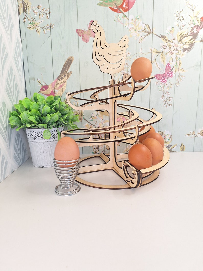 May include: Wooden egg holder shaped like a chicken with a spiral design. The holder is filled with brown eggs.
