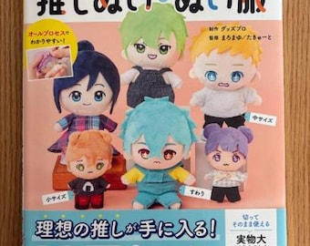 May include: A book cover with the title "推しぬいぬい服" (Oshi Nui Nui Fuku) in Japanese. The cover features illustrations of colourful plush characters with different facial expressions and clothing. The book includes instructions for making plush toys and clothing.