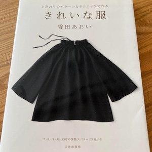 Pode incluir: Um livro intitulado "Kirei na Fuku" (きれいな服) de Aoi Koda (香田あおい) com uma blusa preta na capa. O livro inclui dois padrões de tamanho real para os tamanhos 7-15.