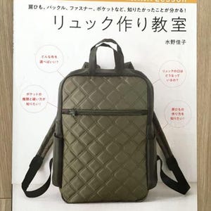 以下が含まれることがあります： 「リュック作り教室」というタイトルの書籍で、表紙には緑色のキルティングリュックが描かれています。書籍の表紙には「リュック作り教室」という文字も書かれており、英語では「Rucksack Making Class」となります。著者は水野佳子です。
