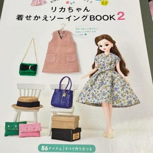 Può includere: Un libro intitolato "リカちゃん 着せかえソーイングBOOK 2" con una bambola che indossa un vestito floreale e un vestito in velluto a coste rosa su un appendiabiti. La copertina del libro presenta una varietà di accessori, tra cui borse, cappelli e scarpe.
