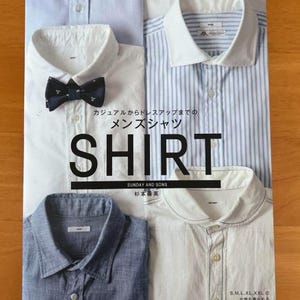 May include: A magazine cover featuring four different shirts: a light blue, a white with a bow tie, a blue and white striped, and a denim shirt. The word "SHIRT" is prominently displayed, with Japanese text above and below.