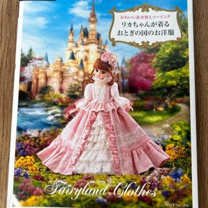 May include: A book cover featuring a doll in a pink and white dress with a castle backdrop. The text "Fairyland Clothes" is at the bottom. The book is titled "Cute Dress-Up Sewing, Licca-chan's Fairytale Dresses."