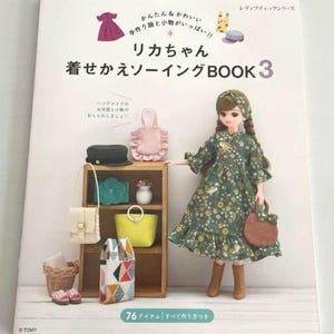 Può includere: Un libro intitolato "リカちゃん 着せかえソーイングBOOK 3" con una bambola che indossa un vestito verde a fiori, una varietà di borse e accessori, e il testo "76 アイテム すべて作り方つき".
