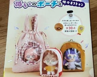 May include: A book with the title "Ai no Pouch to Ton" in Japanese, featuring illustrations of three different fabric pouches with cute doll figures inside. The pouches are made of different fabrics, including a pink and white polka dot fabric, a brown and white fabric, and a yellow fabric. The book is part of a series called "Heart Warming Life Series".