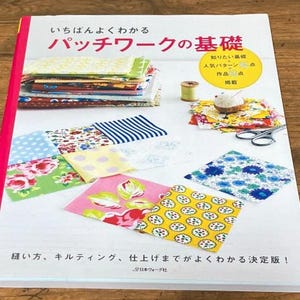 Puede incluir: Un libro en japonés titulado "Patchwork Basics", con muestras de tela, una bobina de hilo y herramientas de costura. La portada muestra texto japonés y una pila de cuadrados de tela. El libro está abierto, mostrando varios patrones de tela.