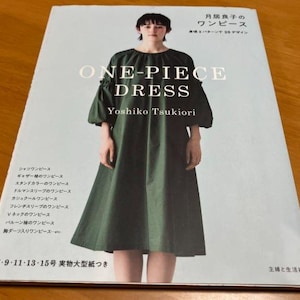 May include: A book titled "One-Piece Dress" by Yoshiko Tsukiori, featuring a green dress with a gathered neckline and long sleeves. The book includes patterns for 30 different dress designs.